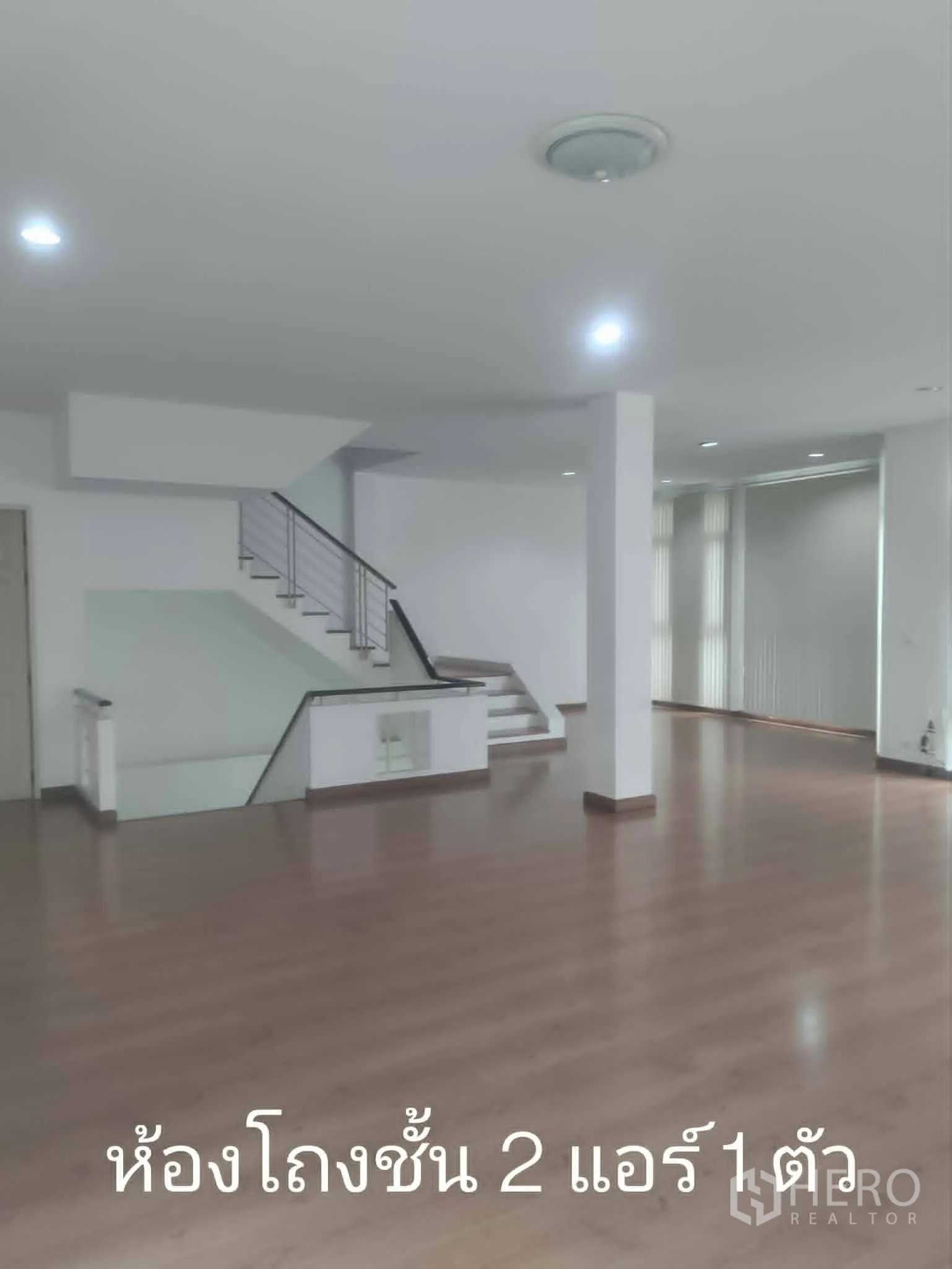 Home Office for rent in Lat Phrao, Bangkok - Open-plan floor with staircase, wood flooring, and window blinds.