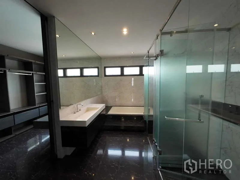 联排别墅 出租或出售在Lat Phrao, Bangkok - 现代浴室，浸泡浴缸、玻璃淋浴间与长台盆，大理石墙面。