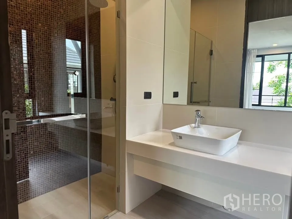 Detached House for sale in Watthana, Bangkok - Modern bathroom with a glass shower and square basin vanity.