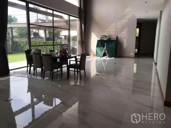 Detached House for rent in Bang Phli, Samut Prakan - Double-height living and dining area with marble floors and full-height windows to the lawn
