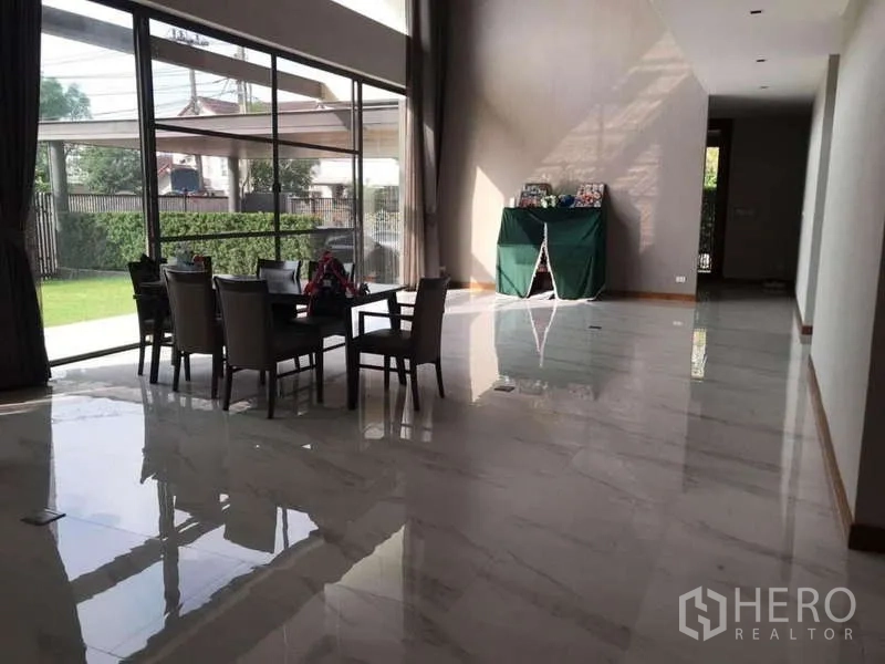 Detached House for rent in Bang Phli, Samut Prakan - Double-height living and dining area with marble floors and full-height windows to the lawn