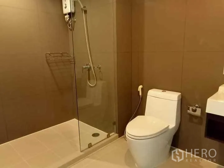 คอนโด ให้เช่าในWatthana, Bangkok - ห้องน้ำสมัยใหม่พร้อมตู้ชาวเวอร์กระจก เครื่องทำน้ำอุ่น และโถสุขภัณฑ์สีขาว.