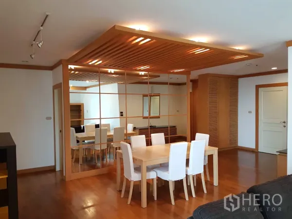 Condominium for rent in Pathum Wan, Bangkok - Open-plan living and dining room with wooden accents, track lighting and a full mirrored wall.