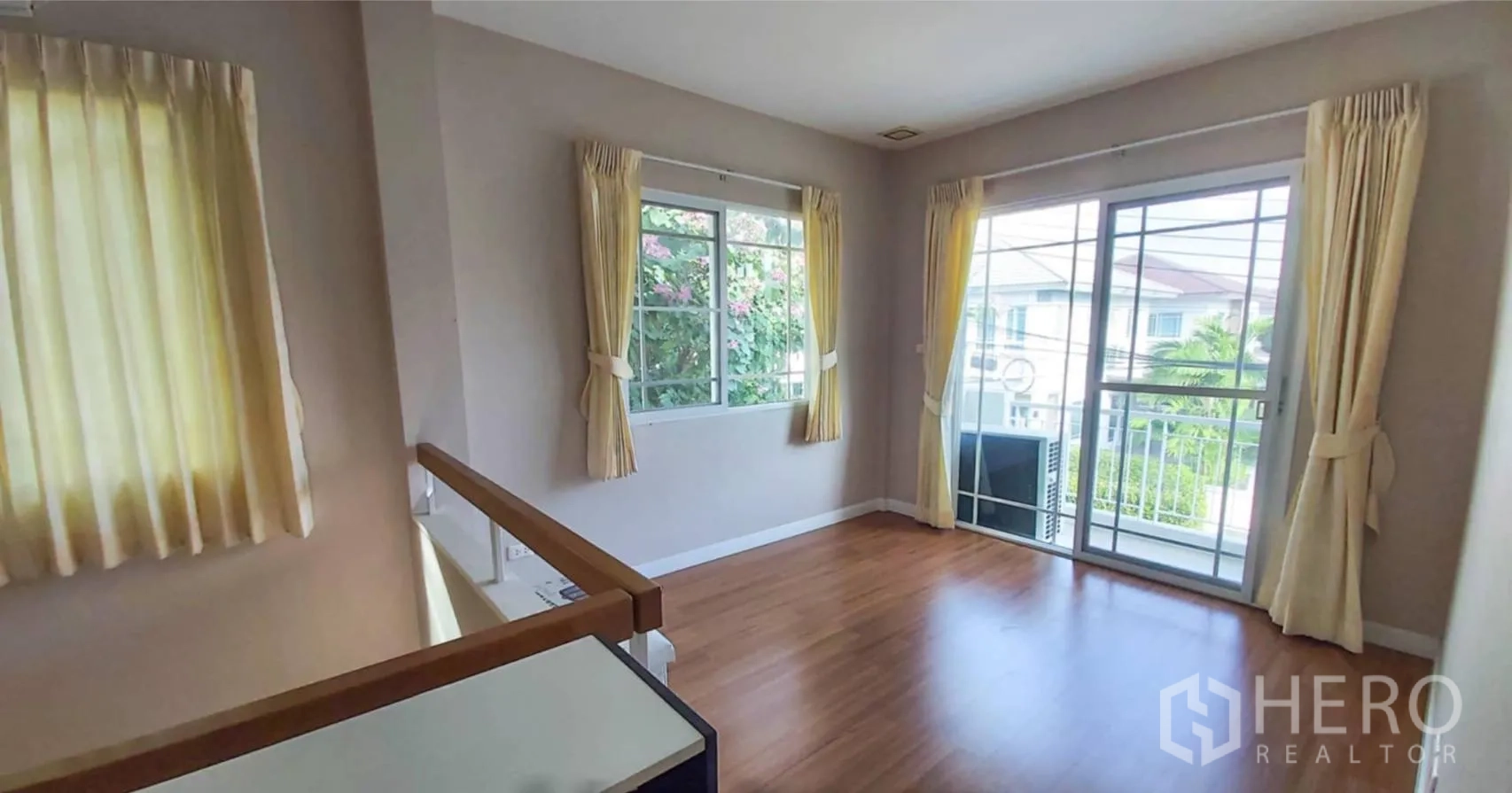 บ้าน for sale in Bang Kapi, Bangkok - โถงชั้นบนปูพื้นไม้ มีหน้าต่างมุมห้องและประตูกระจกออกระเบียง