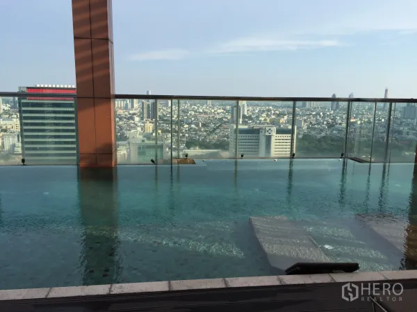 公寓 出租或出售在Bang Rak, Bangkok - 屋顶无边泳池与玻璃护栏，俯瞰曼谷城市天际线。