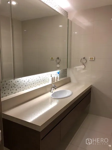 คอนโด ให้เช่าหรือขายในKhlong Toei, Bangkok - ห้องน้ำร่วมสมัยพร้อมเคาน์เตอร์ยาว กระจกบานใหญ่ และไฟนุ่มนวล