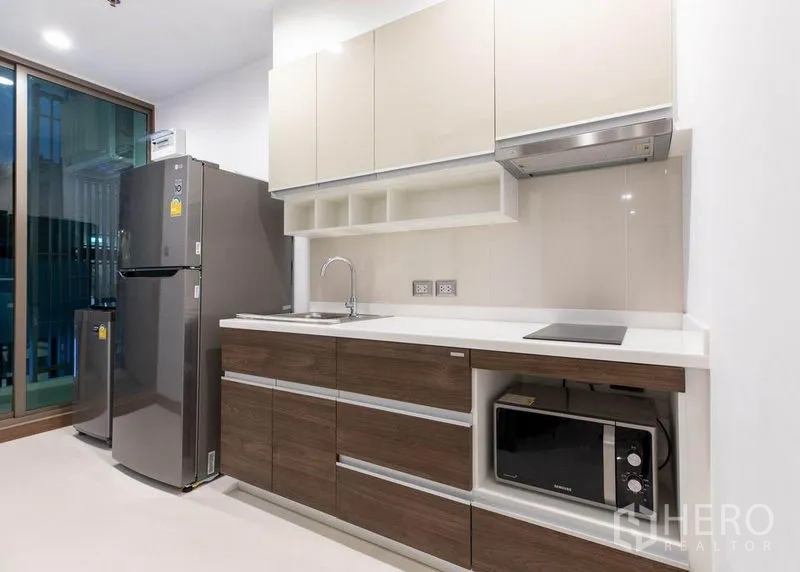 คอนโด ให้เช่าหรือขายในWatthana, Bangkok - ครัวสว่าง เคาน์เตอร์สีขาว ตู้ลายไม้ พร้อมตู้เย็นและไมโครเวฟ