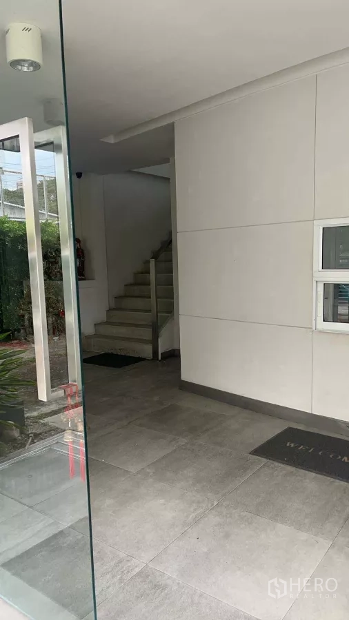 Home Office for rent in Khlong Toei, Bangkok - Glass entryway with tiled lobby and staircase leading to upper floors.