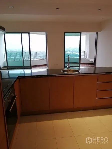 Condominium for sale in Yan Nawa, Bangkok - Kitchen island facing the living room and balconies with city and river views.