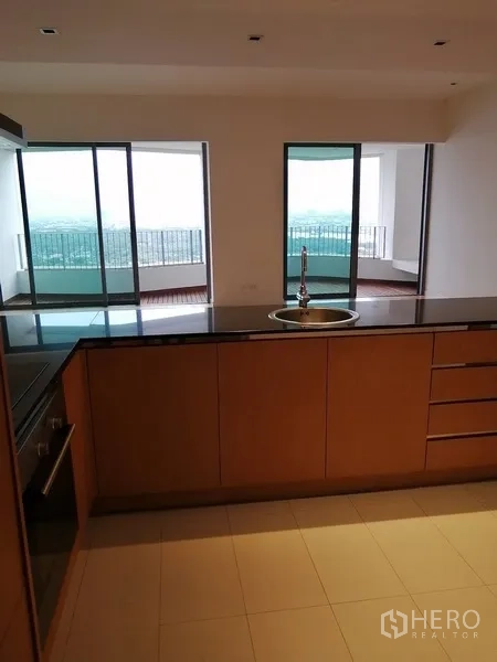Condominium for sale in Yan Nawa, Bangkok - Kitchen island facing the living room and balconies with city and river views.