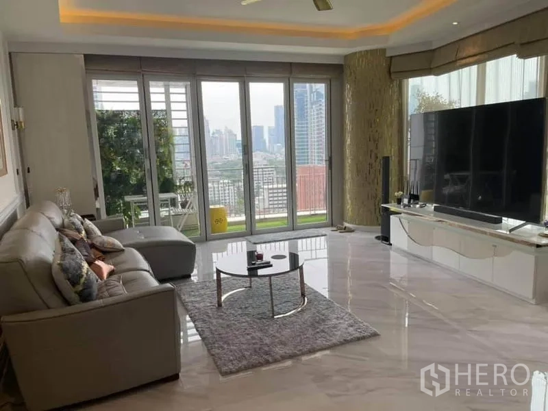 คอนโด ขายในPathum Wan, Bangkok - ห้องนั่งเล่นสว่างพื้นหินอ่อน โซฟาเข้ามุม และหน้าต่างเต็มบานเปิดสู่ระเบียงวิวเมือง