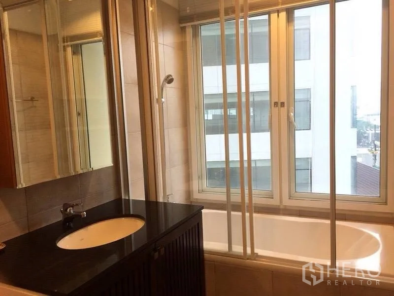 คอนโด ให้เช่าในWatthana, Bangkok - ห้องน้ำมีอ่างอาบน้ำริมหน้าต่าง ชุดเคาน์เตอร์อ่างล้างหน้าหินสีดำและกระจกบานใหญ่