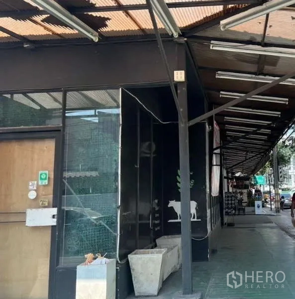 พื้นที่ขายปลีก ให้เช่าในSuan Luang, Bangkok - พื้นที่ค้าปลีกระดับถนนในสวนหลวง หน้าร้านสีดำ กระจกบานใหญ่ ทางเดินมีหลังคา และกระถางต้นไม้