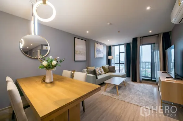 คอนโด ให้เช่าในKhlong Toei, Bangkok - โต๊ะอาหารแจกันดอกไม้ ถัดจากห้องนั่งเล่นและระเบียง