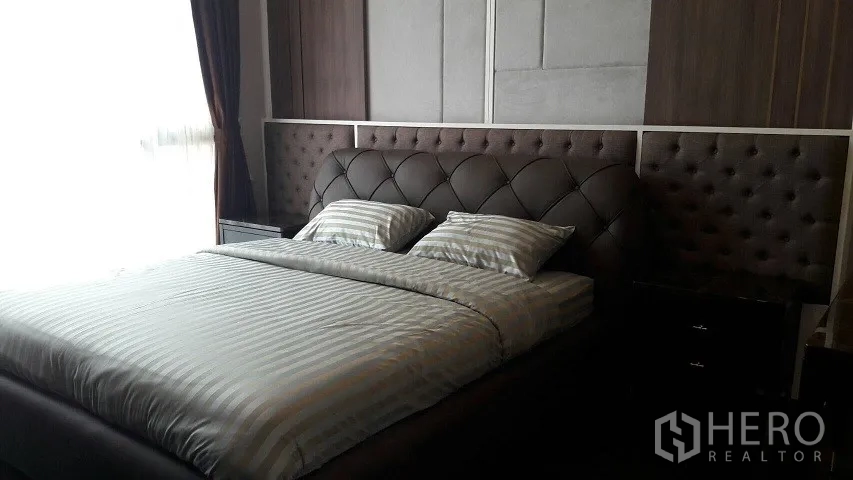 คอนโด ให้เช่าหรือขายในWatthana, Bangkok - ห้องนอนใหญ่พร้อมหัวเตียงบุหนังลายตะเข็บ ชุดเครื่องนอนลายทาง และผ้าม่าน