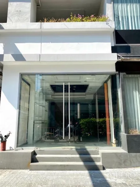 零售空间 出租在Pathum Wan, Bangkok - 一层零售店入口，通高玻璃立面与双开玻璃门，前方台阶，现代白色外立面