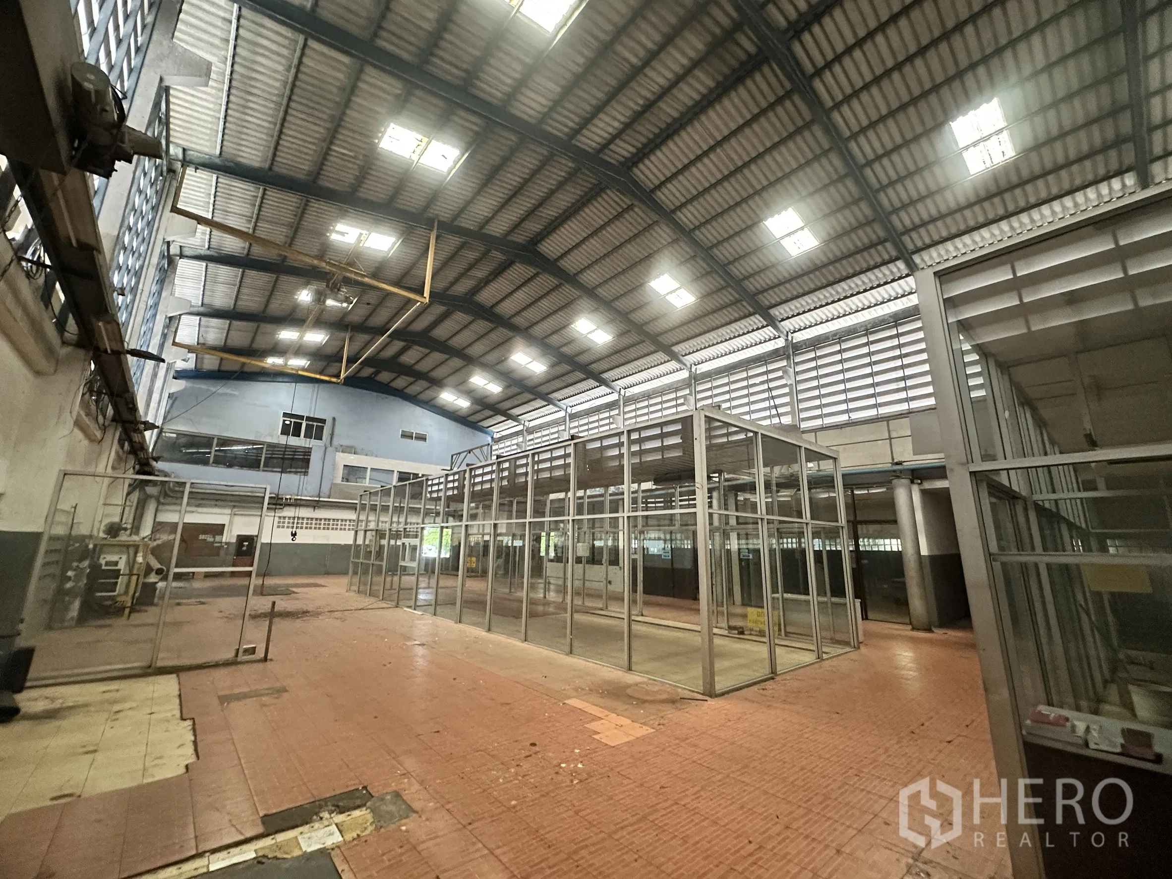 Factory for sale in Bang Bua Thong, Nonthaburi - Large factory hall with high steel roof, skylights, and partitioned production rooms.