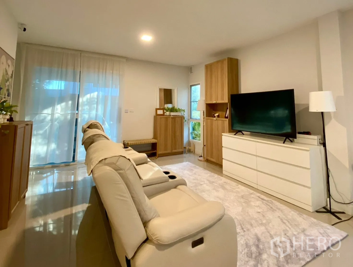 Semi-detached House for rent in Bang Phli, Samut Prakan - Living room with TV cabinet, large rug and floor-to-ceiling curtains.