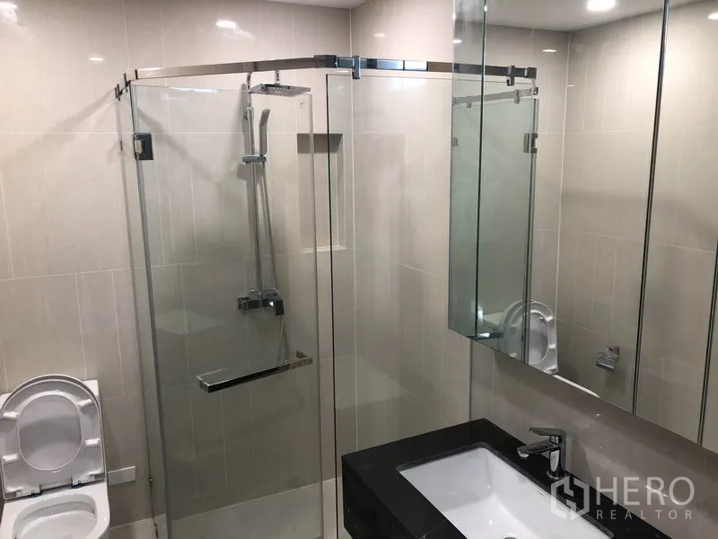 Townhouse for rent in Suan Luang, Bangkok - Modern bathroom featuring a glass shower enclosure, vanity and toilet.