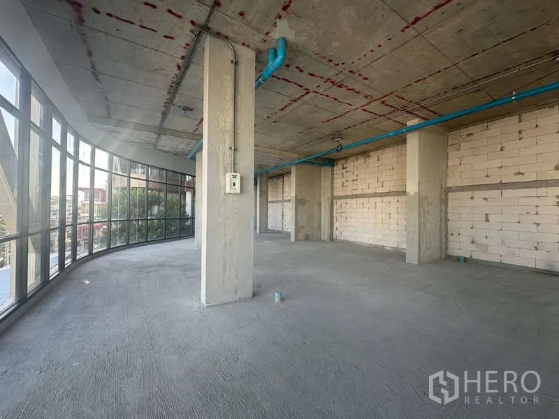 零售空间 出租在Phra Khanong, Bangkok - 转角位置明亮，环幕玻璃、挑高天花与城市景观。