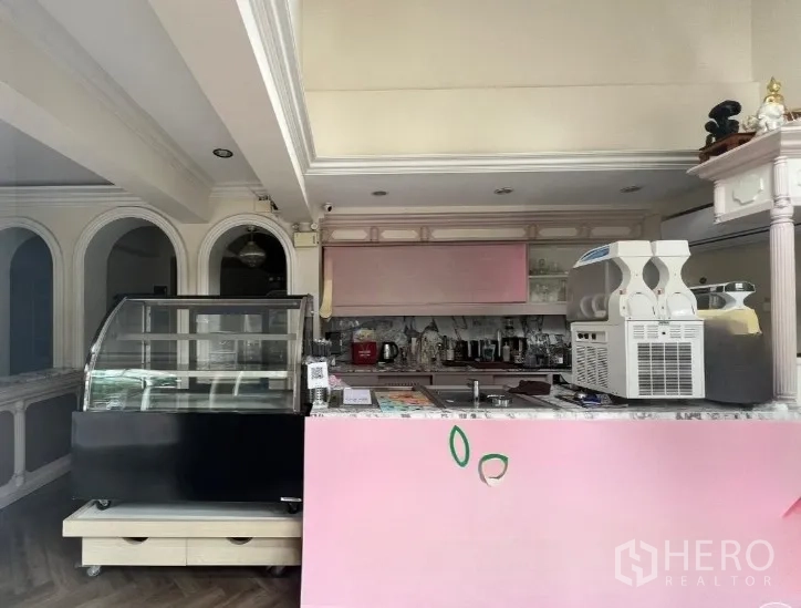 店屋 出租在Phaya Thai, Bangkok - 咖啡馆式粉色吧台，玻璃展示柜与内置搁架。