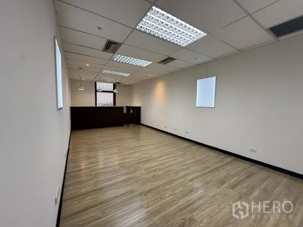 Office Space for rent - Long multipurpose workspace with light wood floors, white walls and a built-in reception counter.