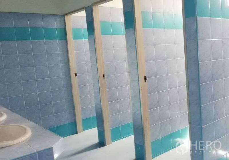 Warehouse for rent in Bang Phli, Samut Prakan - Clean tiled restrooms with multiple stalls and basins in blue and white tones.