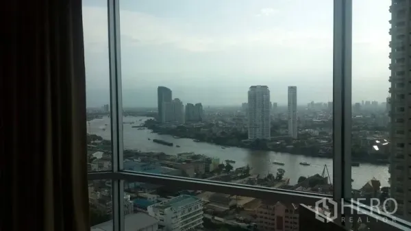 Condominium for rent or sale in Sathon, Bangkok - High-rise window view capturing the Chao Phraya River and surrounding towers.