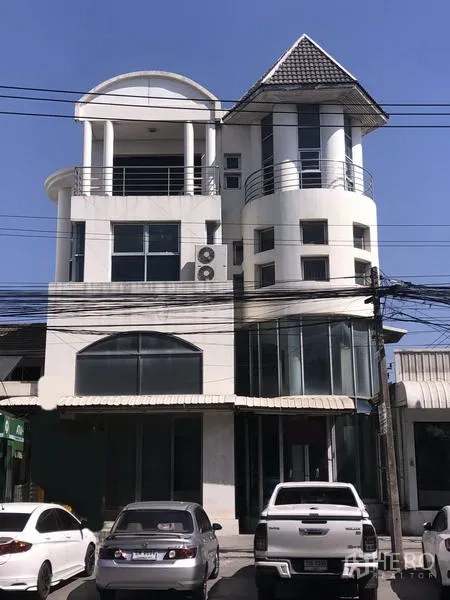 สำนักงานที่บ้าน ให้เช่าในSaphan Sung, Bangkok - อาคารโฮมออฟฟิศสีขาวหลายชั้น ระเบียงโค้ง กระจกหน้ากว้าง และที่จอดรถหน้าตึกบนถนนสายหลักในกรุงเทพฯ
