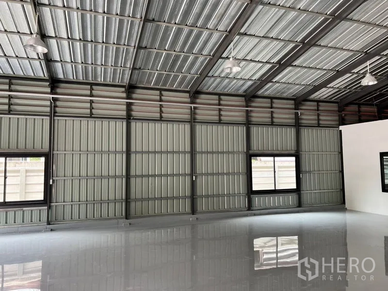 คลังสินค้า ให้เช่าในLat Phrao, Bangkok - ผนังด้านข้างมีช่องลม หน้าต่าง และโคมไฟไฮเบย์แขวน
