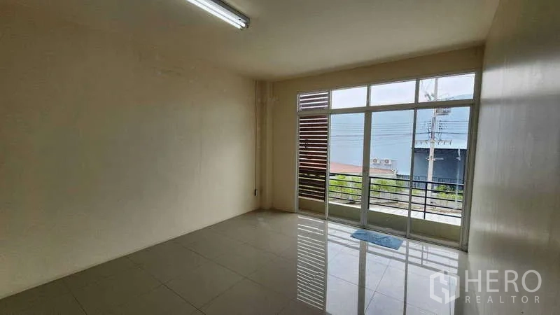 Factory for rent in Samut Sakhon - Bright tiled office with large windows and balcony-style sliding doors.