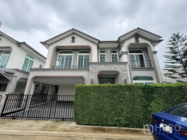 Detached House for rent - Two-storey detached house facade with stone accents, balcony and gated driveway