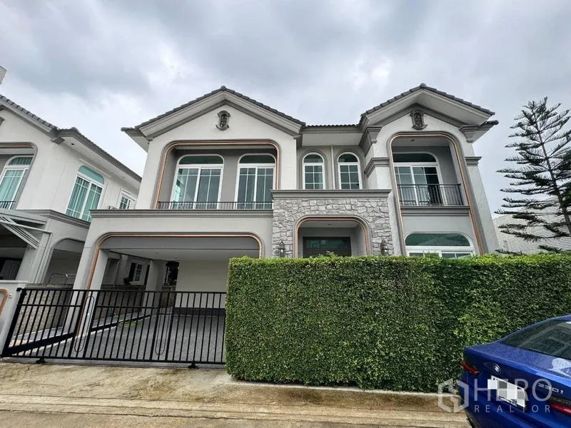 Detached House for rent - Two-storey detached house facade with stone accents, balcony and gated driveway