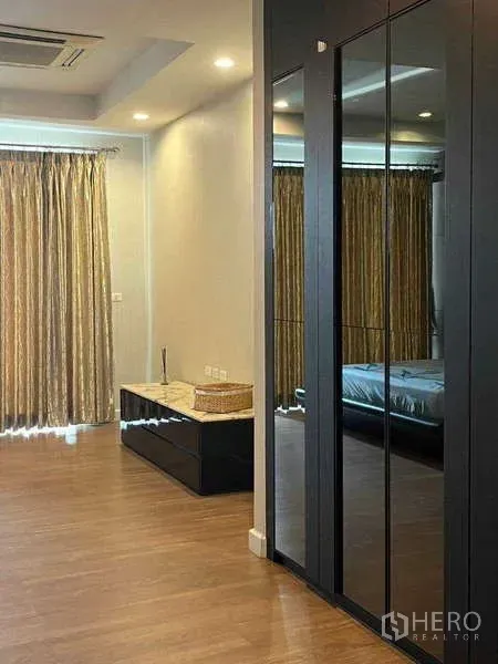 ทาวน์เฮาส์ ให้เช่าในKhlong Toei, Bangkok - มุมห้องนอนกว้างพร้อมตู้เสื้อผ้าบานกระจก พื้นไม้ และผ้าม่านสูงจรดเพดาน