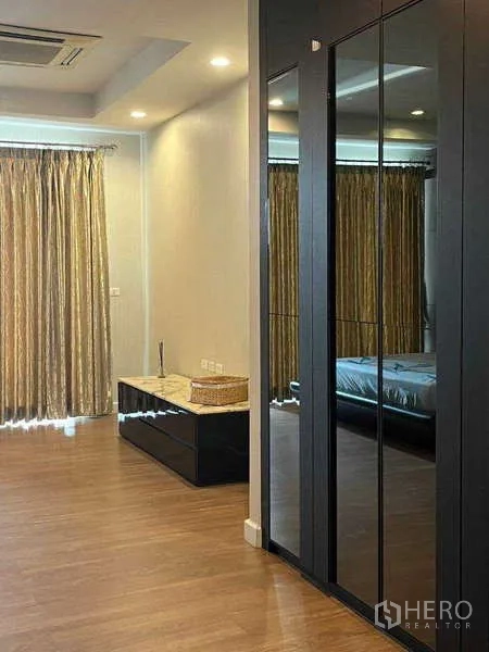 ทาวน์เฮาส์ ให้เช่าในKhlong Toei, Bangkok - มุมห้องนอนกว้างพร้อมตู้เสื้อผ้าบานกระจก พื้นไม้ และผ้าม่านสูงจรดเพดาน