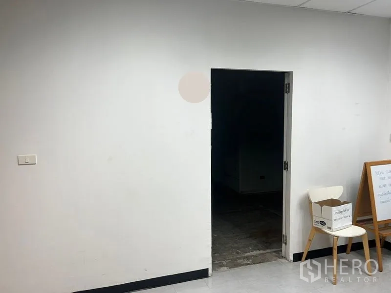 Office Space for rent - Simple entry area with white walls and a doorway leading into the unfinished office floor.