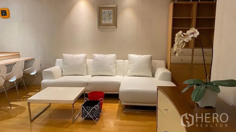 คอนโด ให้เช่าในKhlong Toei, Bangkok - ห้องนั่งเล่นสว่าง โซฟาเข้ามุมสีขาว ชั้นบิลท์อิน และโต๊ะกลางมินิมอล