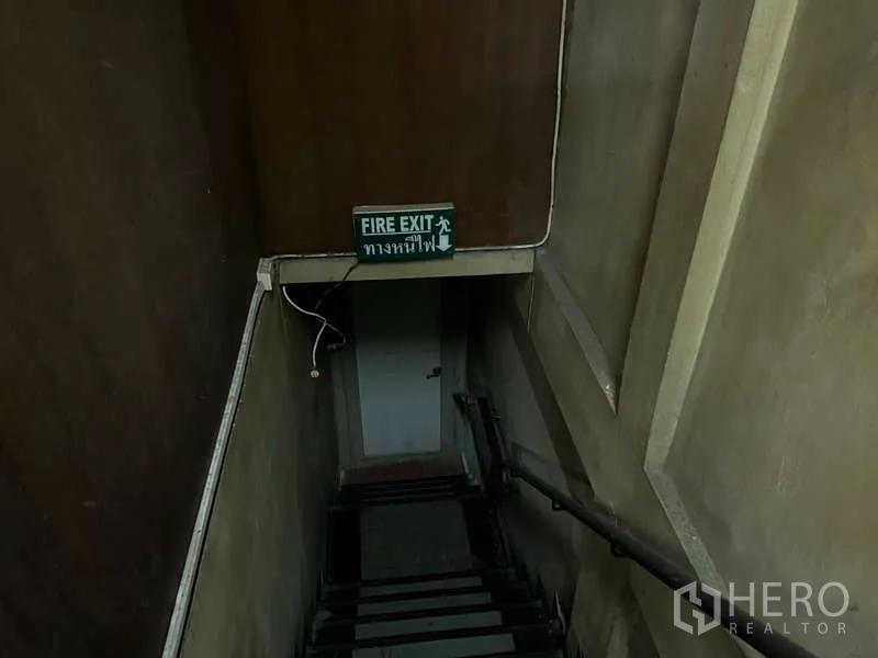 พื้นที่ขายปลีก ให้เช่าในKhlong Toei, Bangkok - บันไดหนีไฟพร้อมป้ายความปลอดภัยและประตูด้านล่าง