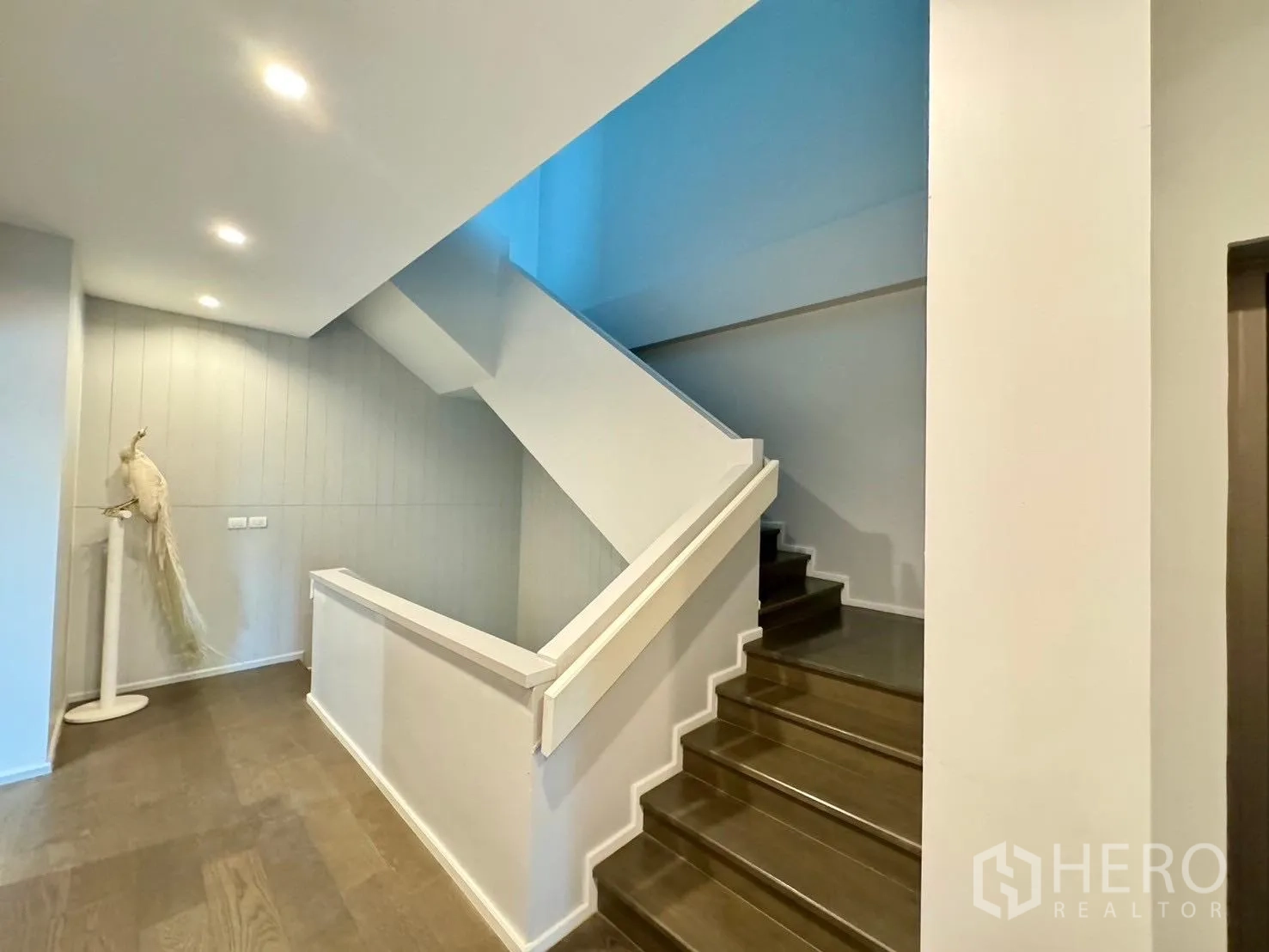 Detached House for rent or sale in Prawet, Bangkok - Staircase with wooden steps, white balustrade and recessed lighting.