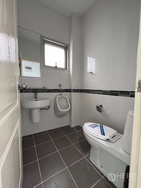 Home Office for sale in Lat Krabang, Bangkok - Compact restroom with sink, toilet, wall urinal and frosted window.