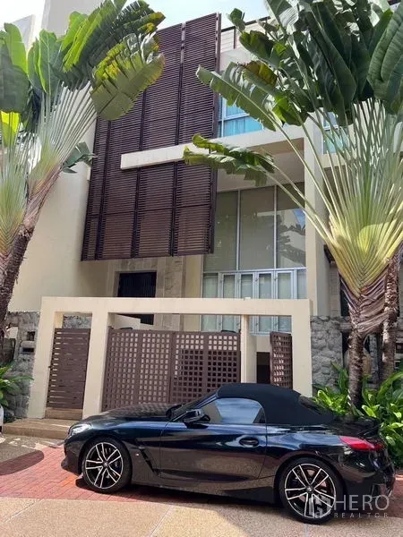 ทาวน์เฮาส์ ขายในYan Nawa, Bangkok - มุมมองหน้าบ้านมีรั้วและสวนทรอปิคอล พร้อมระแนงไม้ตกแต่ง