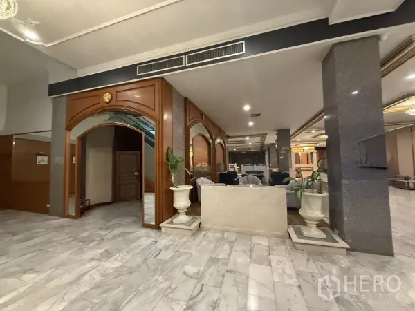 零售空间 出租在Pathum Wan, Bangkok - 大堂全景，石材地面、立柱、拱形门洞与休息座位。