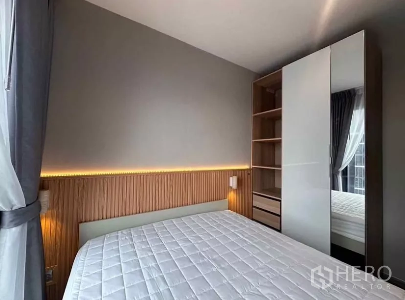 Condominium for rent in Chatuchak, Bangkok - Primary bedroom with wardrobe and LED headboard accent lighting.