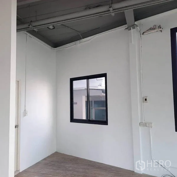 零售空间 出租在Lat Phrao, Bangkok - 小巧角落，白色墙面、木纹地面与窗户。