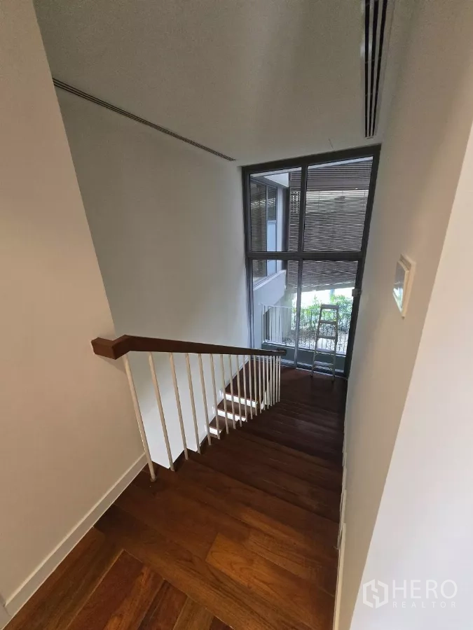 公寓 出租在Yan Nawa, Bangkok - 木质楼梯配白色扶手，旁有挑高落地窗引入自然光。