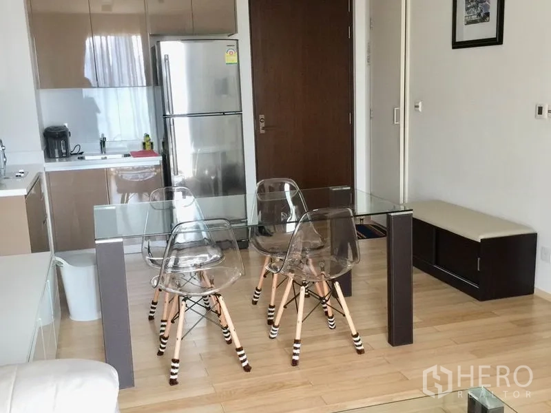 คอนโด ให้เช่าในKhlong Toei, Bangkok - ครัวขนาดกะทัดรัดพร้อมตู้เย็นสแตนเลส และโต๊ะอาหารกระจกกับเก้าอี้ใส.