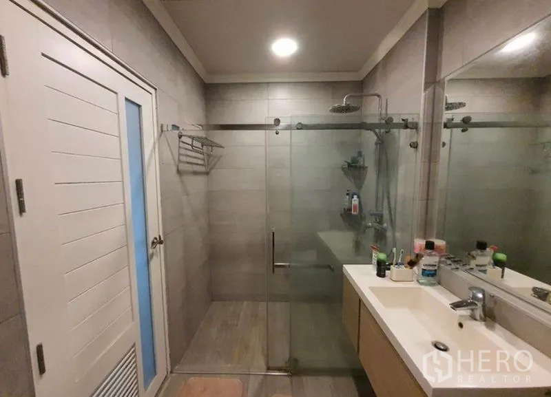 独立式住宅 出售在Sai Mai, Bangkok - 现代卫浴，玻璃淋浴间与带大镜面的洗手台。