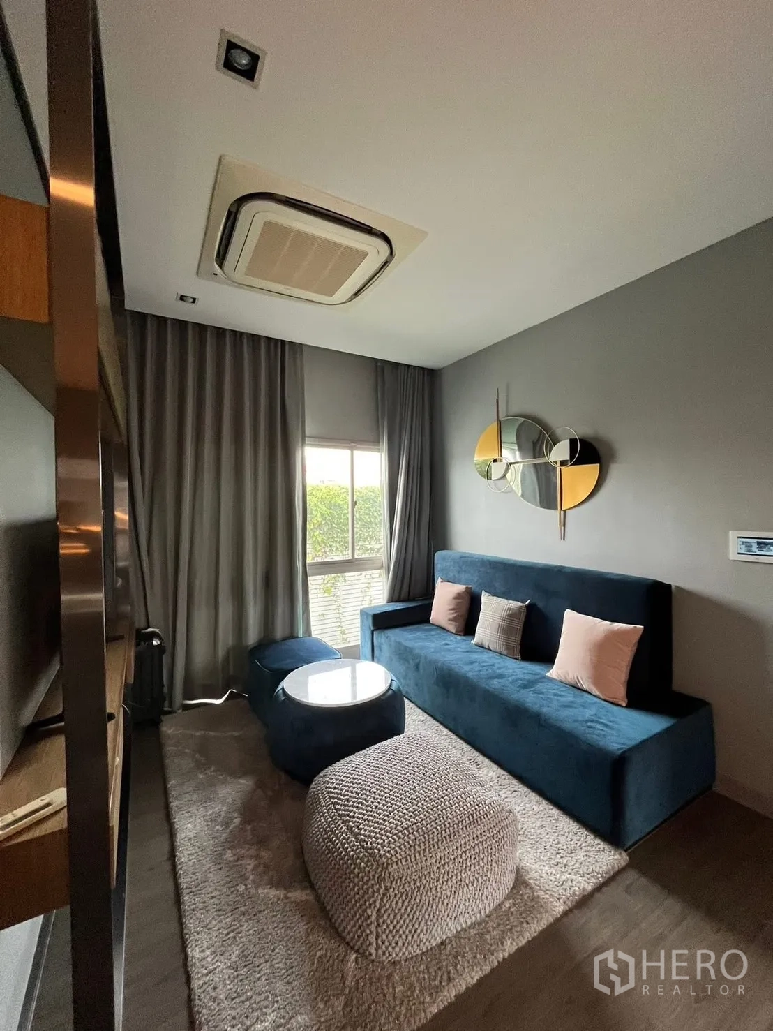 独栋房屋 for rent or sale in Bueng Kum, Bangkok - 影音休闲室配蓝色沙发、脚凳与大窗帘。