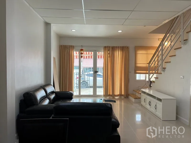 ทาวน์เฮาส์ ให้เช่าในWang Thonglang, Bangkok - โถงนั่งเล่นแบบเปิดโล่ง มีหน้าต่างบานใหญ่ ผ้าม่าน และบันไดขึ้นชั้นบน