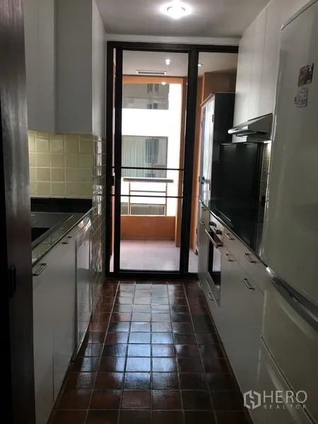 Condominium for rent in Pathum Wan, Bangkok - Galley kitchen with white cabinetry, tiled backsplash, and access to a utility balcony.